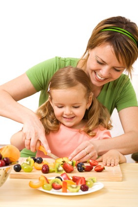 Woman and little girl preparing fruit salad